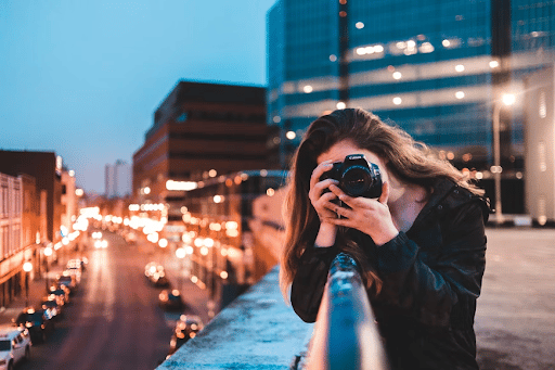 woman holding a photo camera taking a picture / Credit: Unsplash
